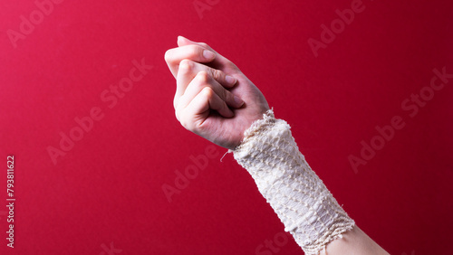 a bandaged female hand on a colored background