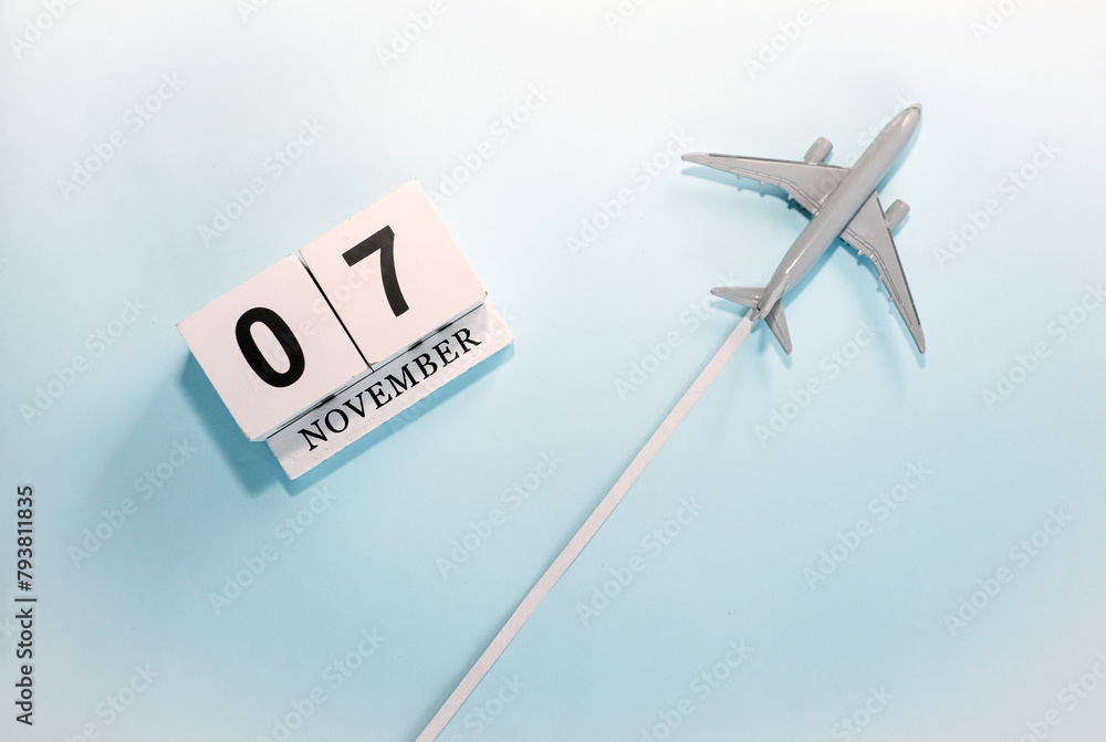 November calendar with number 7. Top view of a calendar with a flying passenger plane. Scheduler. Travel concept. Copy space. November calendar with number 7. Top view of a calendar with a flying passenger plane. Scheduler. Travel concept. Copy space.