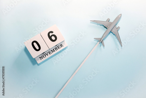 November calendar with number  6. Top view of a calendar with a flying passenger plane. Scheduler. Travel concept. Copy space.