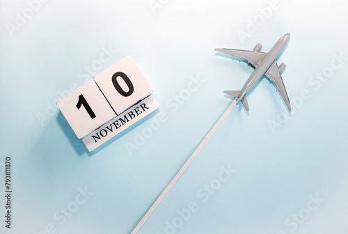 November calendar with number  10. Top view of a calendar with a flying passenger plane. Scheduler. Travel concept. Copy space.