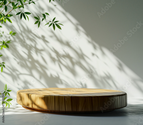 Wooden podium for product presentation in sunlight and shadows on the white wall. Minimalistic abstract gentle light blur background.