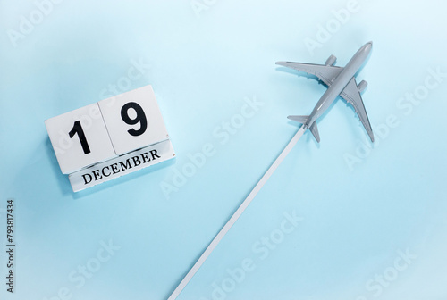 December calendar with number  19. Top view of a calendar with a flying passenger plane. Scheduler. Travel concept. Copy space.