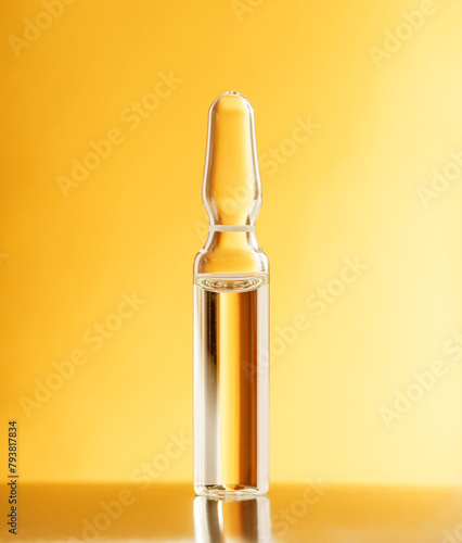 Glass ampoule on a gold orange background. Blister with liquid. Pharmaceutical equipment concept © Baurzhan I