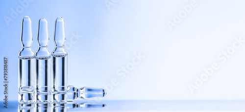 Four ampules over desk on blue background. Concept of medicine © Baurzhan I