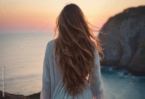 Young woman enjoying a sunset by the sea. Serenity and natural beauty.
