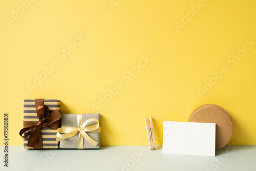 Obraz na płótnie Gift boxes and wrapping accessory on gray desk. yellow wall background w salonie