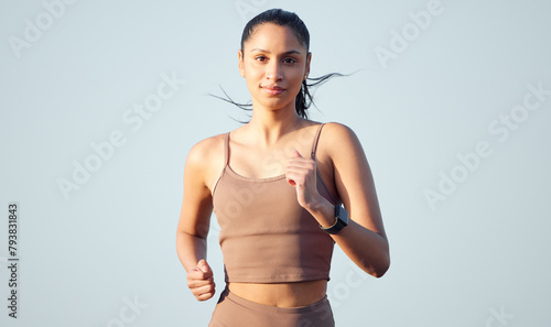 Portrait, fitness and woman running outdoor for body health, wellness or exercise on sky background mockup space. Face, cardio and person training for sport, marathon race or summer workout in Dubai