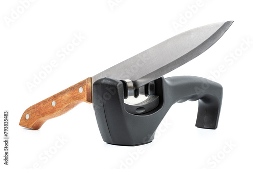 knife with sharpener on the table. Knife and knife sharpener on a white surface. Kitchen tools isolated on white background. Reversible manual knife sharpener. 