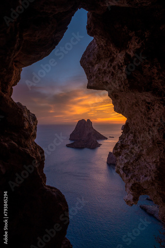 Es Vedra and Es Vendrell islets view through a rock hole in a cave at sunset, Sant Josep de Sa Talaia, Ibiza, Balearic Islands, Spain