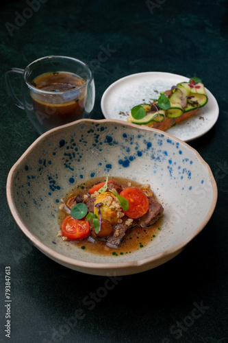 A rustic, but at the same time exquisite dish with juicy meat and bright cherry tomatoes combined with refreshing cucumber toasts. Rich tea completes the culinary experience. (ID: 793847613)