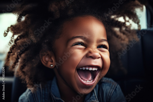 joyful kid laughs in the car, safely in a child seat