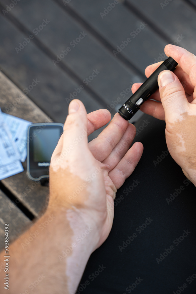 Men checking their sugar levels using a glucometer Men checking their sugar levels using a glucometer