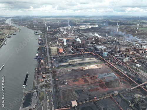 Steelmaking at blast furnace Ghent in Belgium. Cranes at loading port for ships to load and unload raw materials in the steel production process. Aerial drone view. © Sepia100