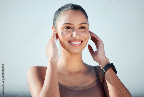 Woman, smile and earpods for running outdoor, fitness and cardio with audio streaming for entertainment. Listening to music, sound and wireless tech with connection, exercise and energy in nature photo