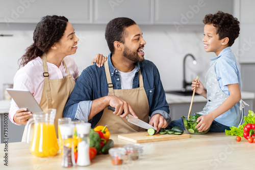 Family engaged in cooking and digital technology