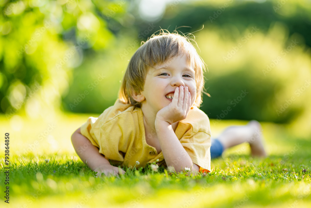 Adorable little boy having fun outdoors on sunny summer day. Kid running outdoors. Child exploring nature. Summer activities for small kids. Adorable little boy having fun outdoors on sunny summer day. Kid running outdoors. Child exploring nature. Summer activities for small kids.