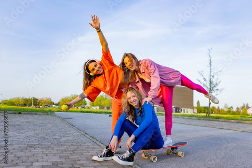 Ragazze in città che si divertono correndo sullo skateboard. photo