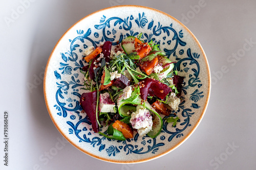 Sumptuous beetroot salad, tangy feta, quinoa sprinkle, in a handcrafted blue-patterned bowl. Vibrant, healthy gastronomy with an artisanal touch. (ID: 793868429)