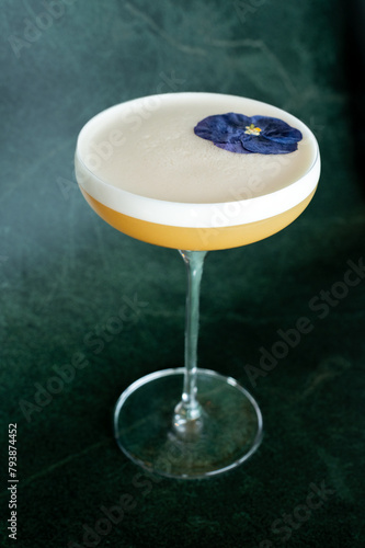 Velvety cocktail creation, crowned with a delicate foam layer and a single vibrant flower. Experience elegance in a glass with this expertly mixed drink. (ID: 793874452)