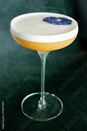 Velvety cocktail creation, crowned with a delicate foam layer and a single vibrant flower. Experience elegance in a glass with this expertly mixed drink. (ID: 793874647)