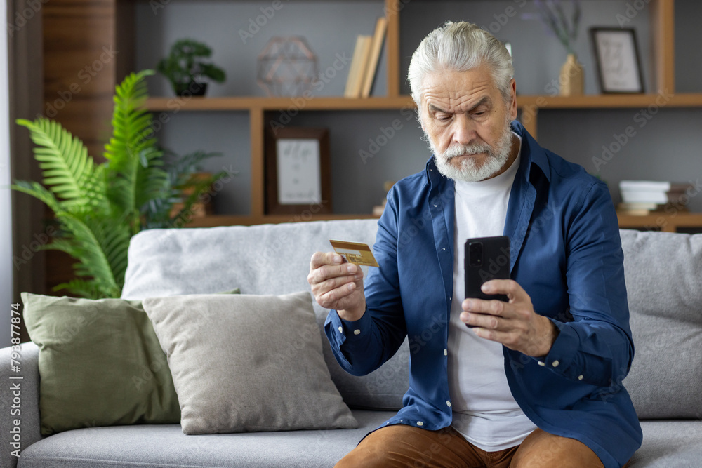 Senior man confused while using credit card and smartphone Senior man confused while using credit card and smartphone