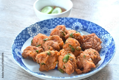 deep fried fish patty on plate with slice cucumber dipping sweet chili sauce 