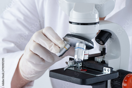 A person is using a microscope in medical laboratory to examine blood. DNA blood test.