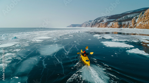 Kayak sailing between ice floes on the lake. photo
