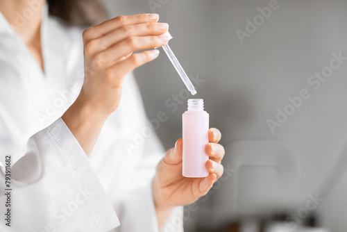 Close-up of woman hands holding skincare dropper