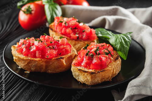 delicious Italian bruschetta with tomatoes on a black wooden rustic background
