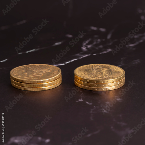 Paris, France - 03 26 2024: Still life. Close-up view stacks of golden american coins on a black and white marble surface.