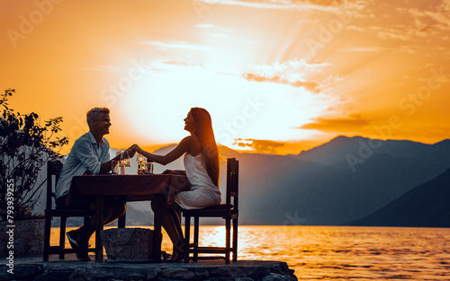 Couple in love drinking champagne wine on romantic dinner at sunset on the beach