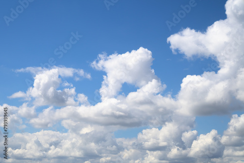 An endless blue sky with white clouds floating over the horizon. Panoramic view of the cloudy sky. Cumulus white clouds. Cloudy weather.