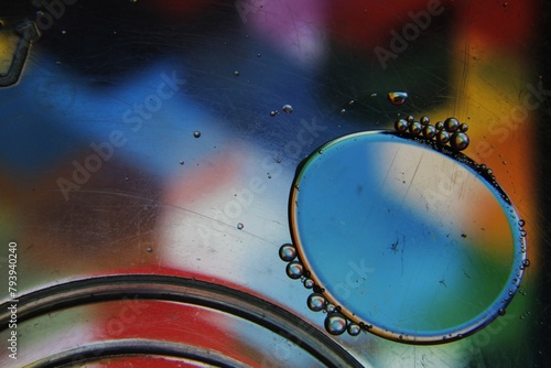 Las burbujas de agua y aceite en la superficie del líquido forman esferas grandes y pequeñas de colores por refracción, original diseño abstracto para fondos.