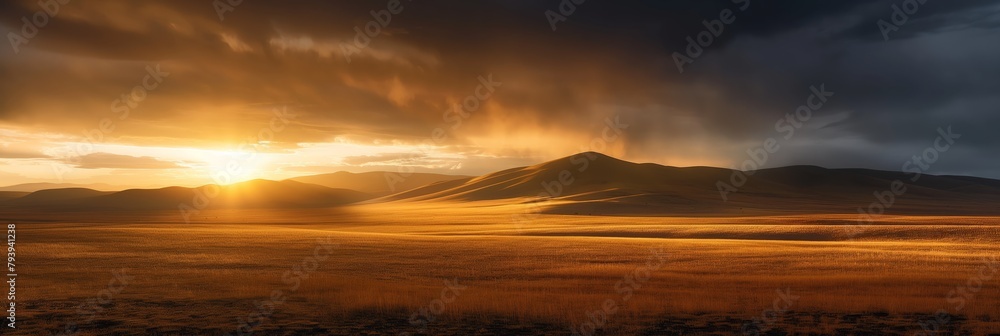 Naklejka premium A captivating photo of the sun setting behind mountains with dramatic clouds casting a golden glow over vast plains