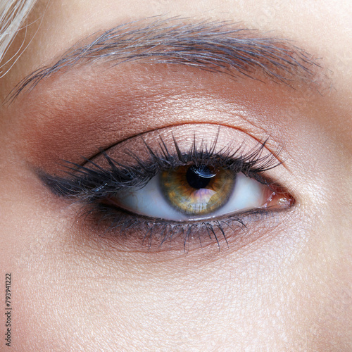 Closeup macro shot of human female eye with black arrows. Woman with natural evening vogue face beauty makeup.