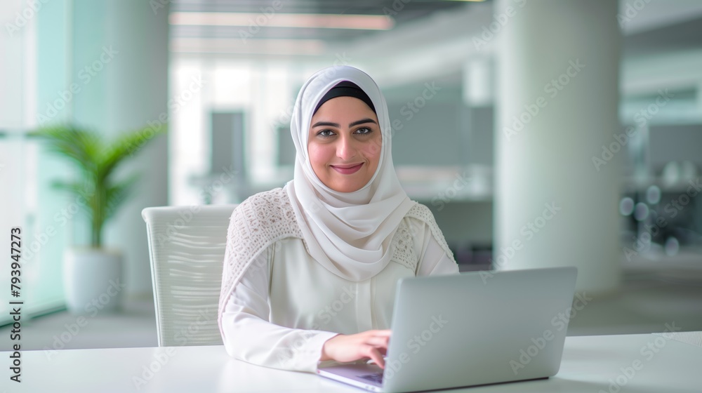 Middle East woman or girl works with on a laptop in the office or a bright and open workspace. Student or remote teacher is working in online education, flexibility of remote work Middle East woman or girl works with on a laptop in the office or a bright and open workspace. Student or remote teacher is working in online education, flexibility of remote work