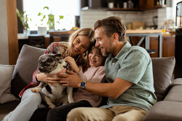 Family bonding time with playful french bulldog pup in cozy living room