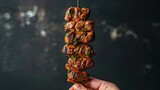 Vibrant shot focusing on a hand holding a delectable Turkish meat kebab on a stick, with a sleek isolated background, studio lighting for vivid detail