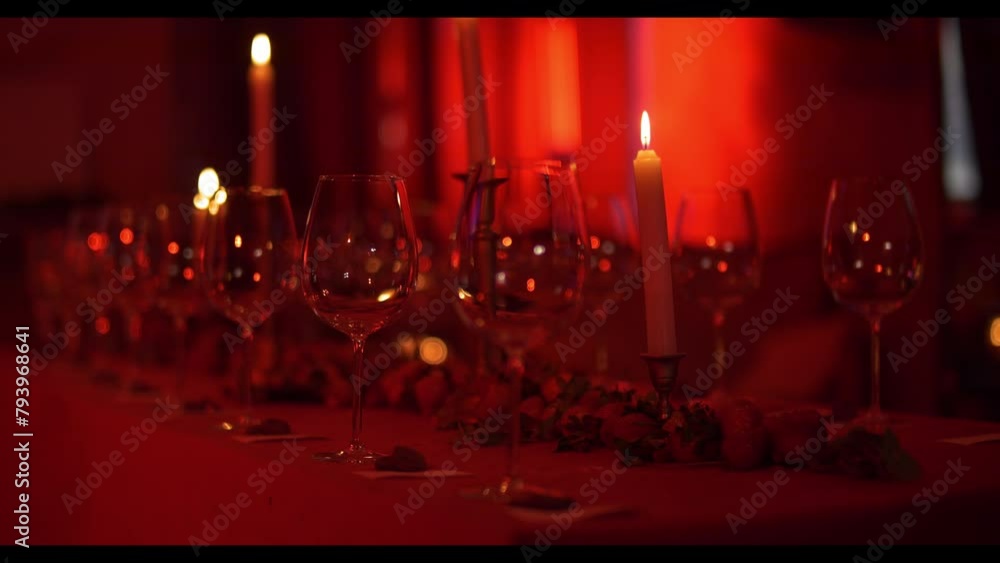empty wine glasses stand on a decorated table in a red light, a social event empty wine glasses stand on a decorated table in a red light, a social event