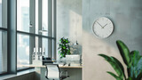 Modern minimalist wall clock with a sleek, simple design, hanging in a contemporary office space, emphasizing functionality and style.