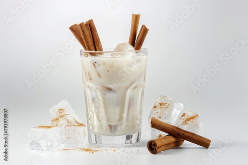 A refreshing glass of horchata, garnished with cinnamon sticks and ice cubes, a traditional Mexican rice milk drink.