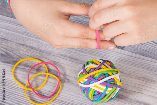 Preschooler hands playing with rubber bands or erasers. Development of kids motor skills, coordination logical thinking