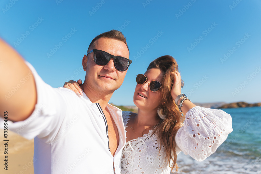 Young happy couple taking selfie on the beach. Summer vacations concept. Young happy couple taking selfie on the beach. Summer vacations concept.