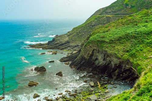 rocky shore with green vegetation. Atlantic coast in Spain, Basque Country. Camino de Santiago