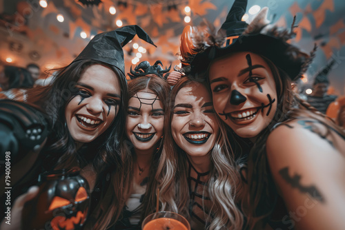 Cheerful young people dressed up as crazy witches, demons, vampires, having fun at a Halloween party.