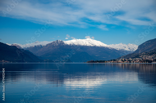 Driving car along shores of Lake Como in Northern Italy  spring sunny days  views of alpine mountains  water and villages