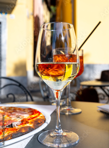 Glass of cold dry white wine served outdoor in cafe in Bellagio, Como lake, Italy