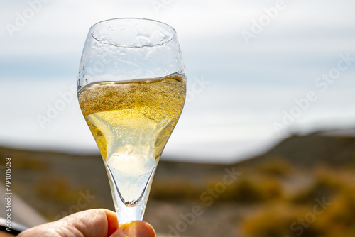 Pouring a glass of champagne on vacation, south of Fuerteventura, Canary islands, blue ocean, mountains photo