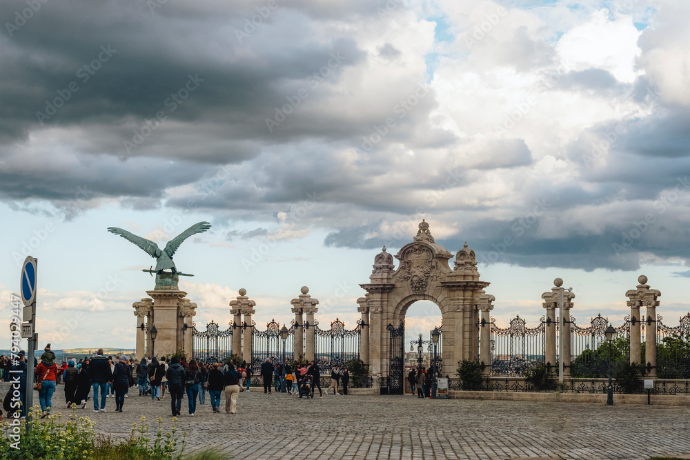 The Turul Bird Statue at the gate entrance to the Royal Palace and crowd of unrecognizable people. Budapest, Hungary
